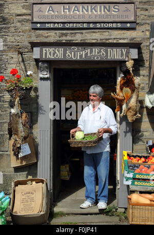 John Derbyshire, Besitzer des "Hankins Gemüsehändler und Fruiterer" in Hayfield, Derbyshire; als BBC Drehort für "The Village". Stockfoto
