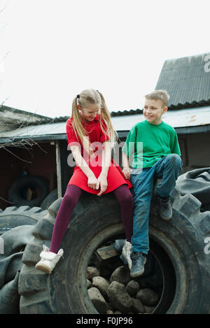 Kinder spielen im Schrottplatz Reifen Stockfoto