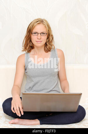 Stilvolle junge Frau in schwarzen Gläsern mit laptop Stockfoto