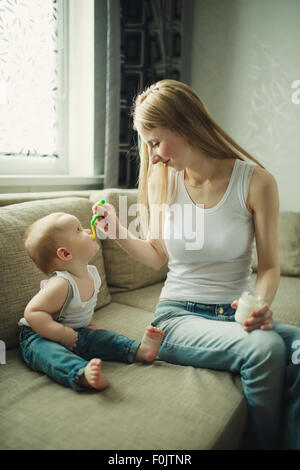 Mutter Baby mit einem Löffel füttern Stockfoto