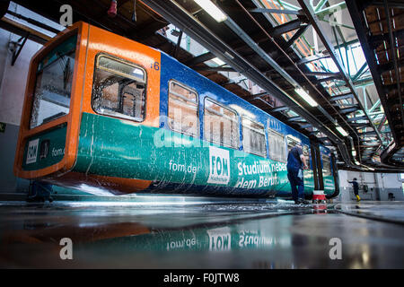 Wuppertal, Deutschland. 13. August 2015. Ein Mann reinigt einen Wagen in der Werkstatt von der Schwebebahn befindet sich an der Endstation in Wuppertal, Deutschland, 13. August 2015. Wuppertaler Stadtwerke WSW wird drei Wagen des bekannten Bahn, verschenken mit einem zusätzlichen 21 aus den 1970er Jahren bis nächstes Jahr, wenn die vierte Generation der Eisenbahn geplant ist, die direkte Geschäftstätigkeit, für 5.000 Euro verkauft werden. Foto: Maja Hitij/Dpa/Alamy Live News Stockfoto