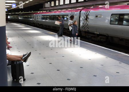 Fahrgäste im Eisenbahnverkehr warten auf einen Zug am Bahnhof Euston Stockfoto