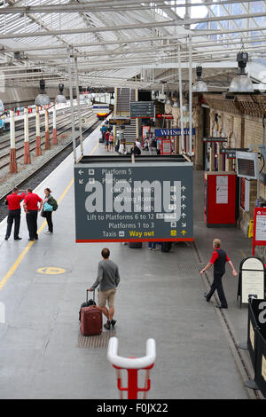 Passagiere warten auf eine Jungfrau Zug nach London, am Bahnhof Crewe, England Stockfoto