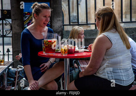 Zwei junge Frauen chatten über einen Krug Pimms, London, England Stockfoto