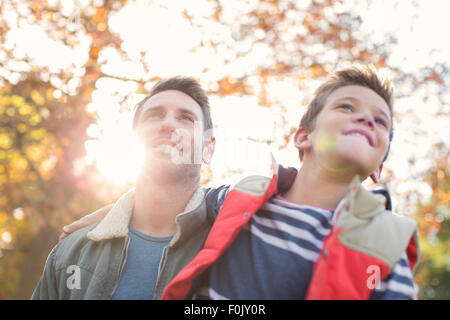 Vater im Sohn unter sonnigen Herbst Baum Stockfoto