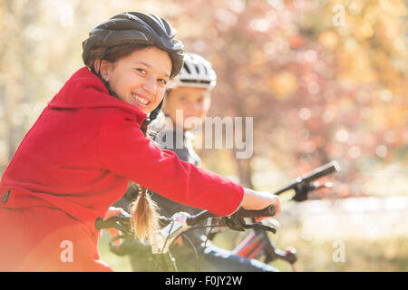 Porträt-begeisterten Mädchen-Fahrrad fahren mit jungen Stockfoto