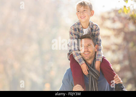Lächelnden Vater mit Sohn auf Schultern im freien Stockfoto