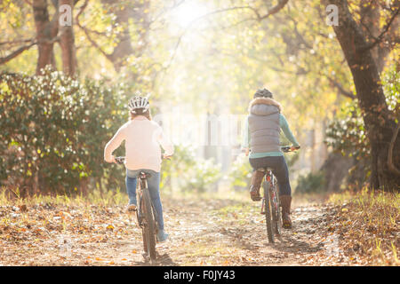 Mutter und Tochter Radfahren auf Weg im Wald Stockfoto