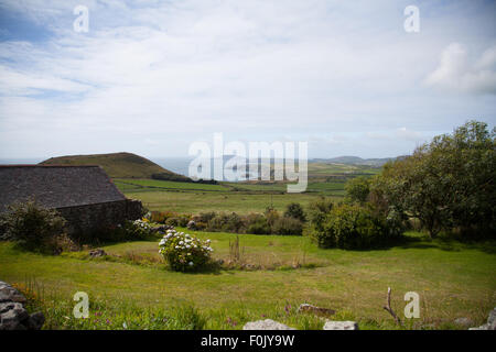 Ein Blick vom Carreg Lefain, Rhiw über Felder, Penarfynydd mit dem Meer und Ynys Enlli in der Ferne an einem Sommertag Stockfoto