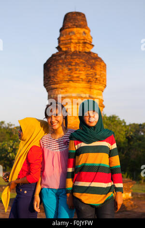 Junge Frauen posieren für ein Foto vor dem Hintergrund der Mahligai Stupa auf dem Muara Takus Tempelgelände in Kampar, Riau, Indonesien. Stockfoto