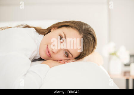 Porträt heitere Frau auf Bett Stockfoto