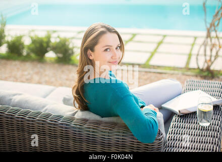 Porträt, Lächeln Magazin Woman Lesung am Luxus Pool Stockfoto