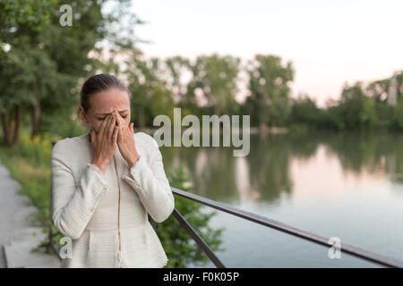 Junge Frau am Hafen neben einem Geländer zu weinen Stockfoto