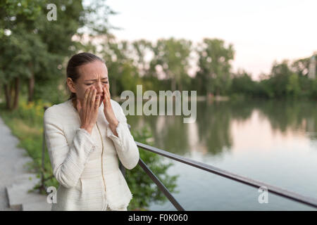 Junge Frau am Hafen neben einem Geländer zu weinen Stockfoto