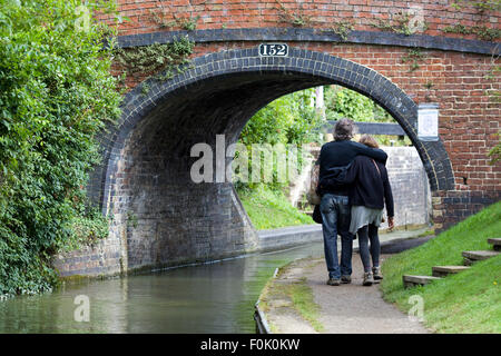 Paare, die Arm in Arm durch Cropredy Lock Brücke Nr. 152 Stockfoto