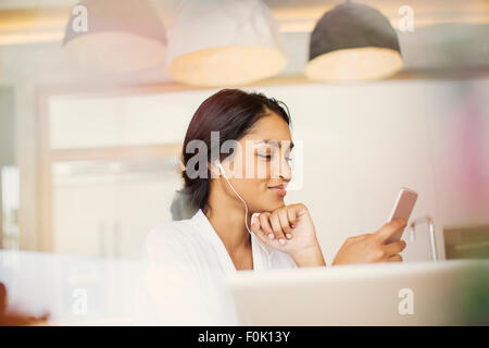 Frau mit Kopfhörern anhören von Musik auf MP3-player Stockfoto
