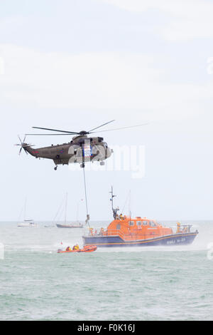 Royal Navy Sea King Hubschrauber simuliert Übertragung einzelner zwischen Flugzeug und Rettungsboot an der Eastbourne Airbourne, UK. Stockfoto
