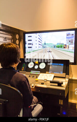 Shinkansen Museum, Nagoya. Blick über die Schulter der Kaukasischen junge Kind 10-12 Jahre alte, sitzen im Control Panel und ein Bildschirm in Train Simulator. Stockfoto