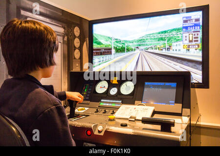 Shinkansen Museum, Nagoya. Blick über die Schulter der Kaukasischen junge Kind 10-12 Jahre alte, sitzen im Control Panel und ein Bildschirm in Train Simulator. Stockfoto