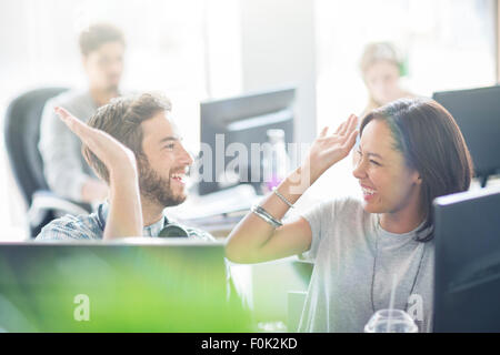 Begeisterte Geschäft Leute hohe Fiving im Büro Stockfoto