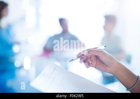 Geschäftsfrau hält Stift Überprüfung Papierkram hautnah Stockfoto