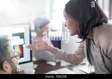 Kreative Geschäftsfrau gestikulieren am Computer im Büro Stockfoto