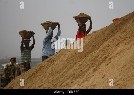 Männliche und weibliche Arbeiter tragen schwere Lasten von Sand auf ihre Köpfe in die Bank von Turag River bei Gabtoli in Dhaka ausgeglichen. Stockfoto