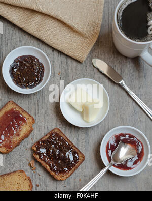 Hausgemachte Paleo, glutenfreies Brot mit Marmelade, Butter und Kaffee serviert. Stockfoto