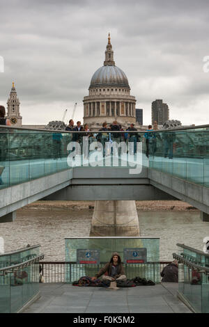 Ein Obdachloser Mann und Hund Betteln auf die Millennium Bridge, St. Pauls Cathedral in der Nähe; London, England GB Stockfoto