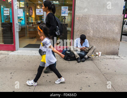 New York City, USA, Straßenszenen, Chinatown District, Frau mit Kind, Spaziergang durch Obdachlosen, der auf Gehsteig sitzt, bettelnd, soziale Versorgungskrise, Armut usa Stockfoto