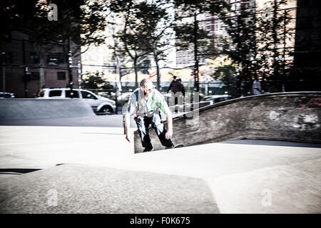 Jungen unter die Manhattan Bridge skateboarding Stockfoto