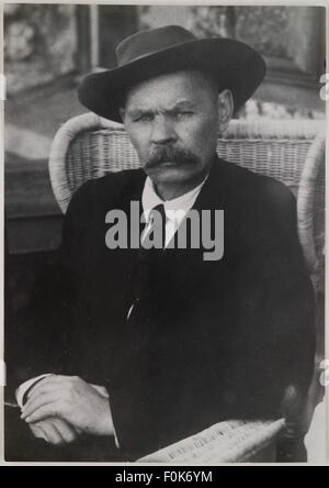 Ein historisches Foto von Maxim Gorki, dem berühmten russischen Schriftsteller und politischen Denker, mit einem Hut auf dem Kopf, wahrscheinlich in einem entspannten oder besinnlichen Moment. Stockfoto