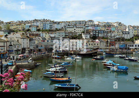 Boote im Hafen von Brixham, Devon, England. Häuser und Restaurants im Hintergrund mit Blick auf den Hafen. Stockfoto