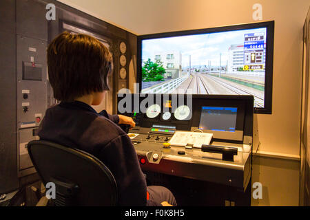 Shinkansen Museum, Nagoya. Blick über die Schulter der Kaukasischen junge Kind 10-12 Jahre alte, sitzen im Control Panel und ein Bildschirm in Train Simulator. Stockfoto