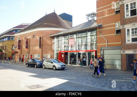 Touristen zu Fuß vorbei an den Haupteingang des Shakespeares Globe Outdoor Theatre in London. Stockfoto