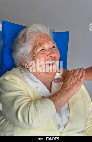 Glückliches Lachen erfüllt ältere Dame hält beruhigend Arm der Pflegeperson Begleiter Stockfoto