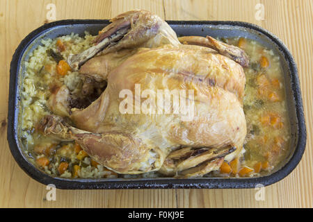 Gebratenes Huhn und Reis-Pilaw auf einem Holztisch. Stockfoto