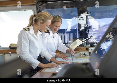 Zwei weibliche nautische Offiziere arbeiten auf eine nautische Karte Stockfoto