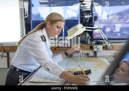 Weibliche Deck Officer arbeiten auf eine nautische Karte Stockfoto