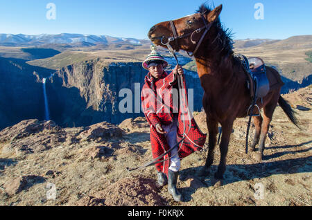 Ein junger Hirte führt sein Pferd entlang der Klippen von Lesotho in der Nähe Maletsunyane Fälle. Stockfoto