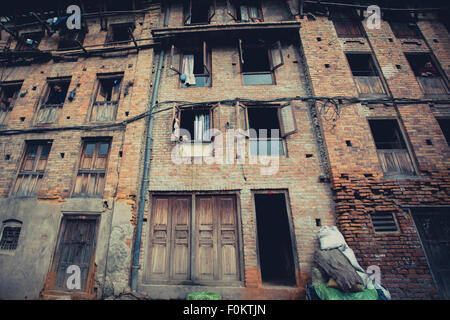 Eine sehr schlechte Fassade in der alten Stadt Bhaktapur und einige lokale Leute draußen, 24. April 2013. Stockfoto