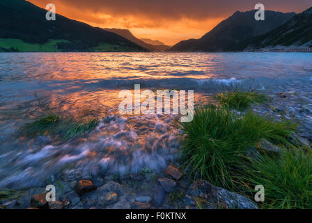 Schöne Aussicht auf den See Resia. Dramatischer Himmel und farbenprächtigen Sonnenuntergang. Alpen, Italien, Europa. Stockfoto
