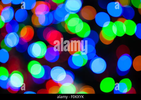 Einen hellen mehrfarbigen Bokeh Hintergrund erstellt durch eine Reihe von de-fokussierten Weihnachtsbeleuchtung. Stockfoto