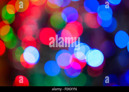 Einen hellen mehrfarbigen Bokeh Hintergrund erstellt durch eine Reihe von de-fokussierten Weihnachtsbeleuchtung. Stockfoto