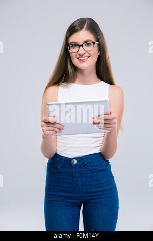 Porträt eines lächelnden weiblichen Teenagers in Gläser halten Tablet-Computer und Blick in die Kamera auf einem weißen Hintergrund isoliert Stockfoto