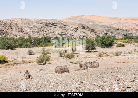 Angolanische Landschaft und Lebensstil: verlassene Fachwerk Lehmhütten in rauen trockenen Wüstenlandschaft, südlichen Angola, Blick über die Grenze nach Namibia Stockfoto