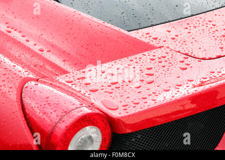 Tröpfchen auf roten Sportwagen nach dem Regen Stockfoto