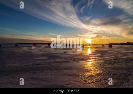 Eisfischen mit Blendenfleck bei Sonnenuntergang an den Ufern des ländlichen Prince-Edward-Insel. Stockfoto