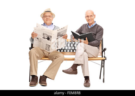 Zwei ältere Herren sitzen auf einer Bank und hält ein Buch und eine Zeitung isoliert auf weißem Hintergrund Stockfoto