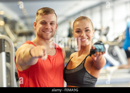 glücklicher Mann und Frau Zeigefinger auf Sie im Fitness-Studio Stockfoto